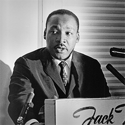 Dr. Martin Luther King Jr, behind a lectern