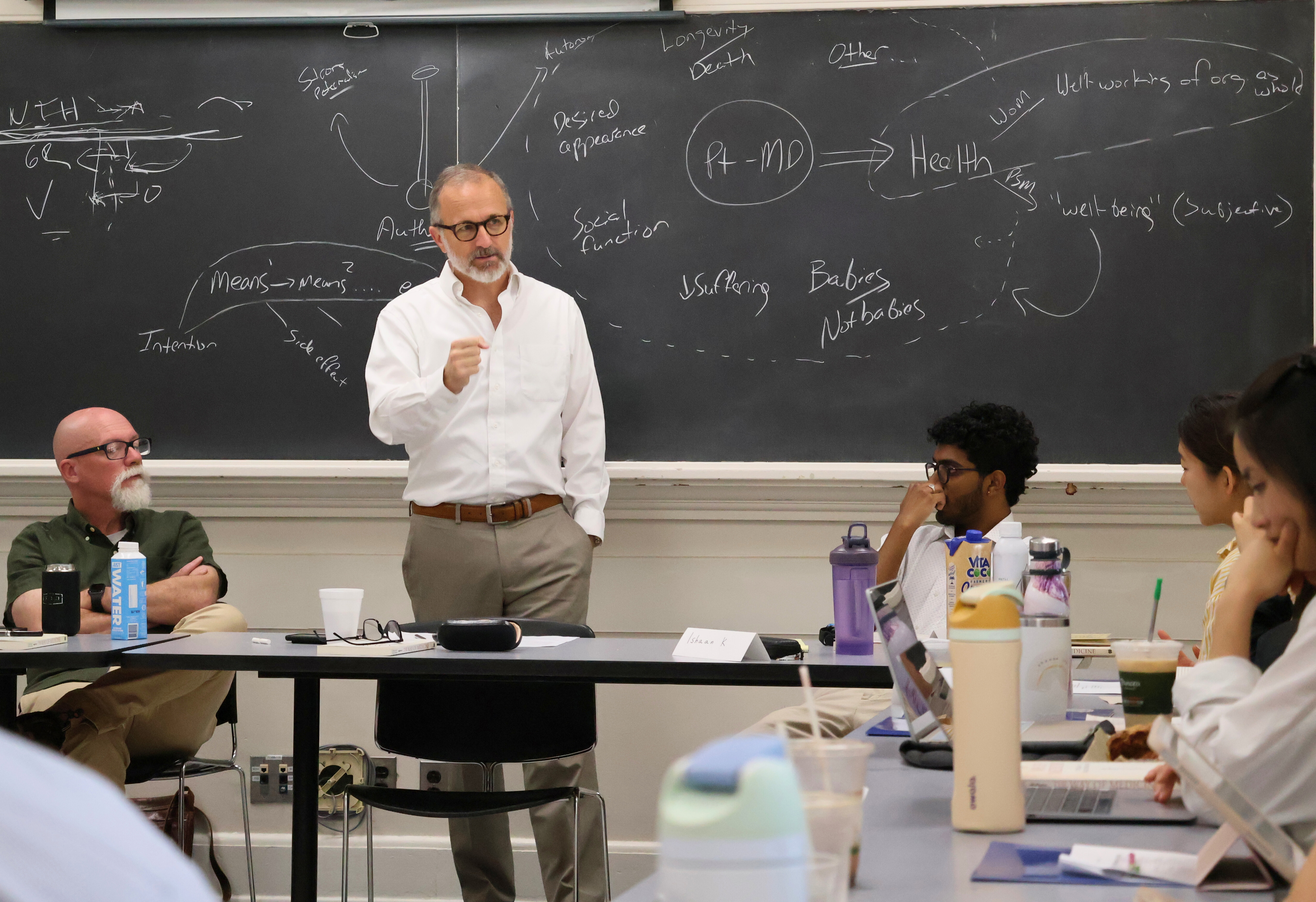 Farr Curlin in front of blackboard teaching undergraduates